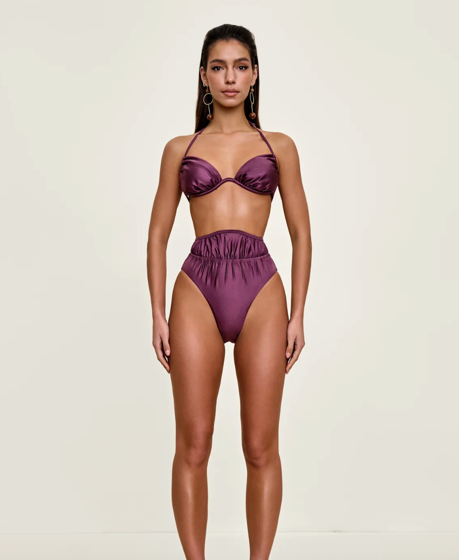 Woman wearing a purple bikini set on a white background