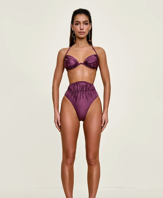 Woman wearing a purple bikini set on a white background